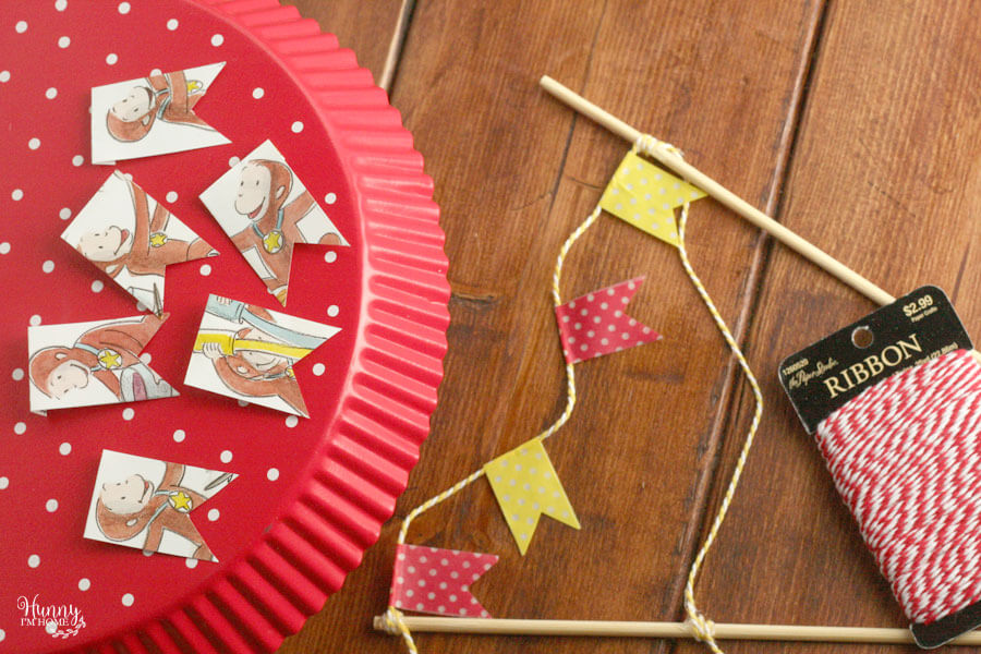 Learn how to make an adorable bunting cake topper out of book pages and washi tape from hunnyimhomediy.com | DIY bunting cake topper | bunting cake topper DIY | bunting cake topper baby | book page cake topper | book page crafts | flag cake topper DIY | book cake topper | DIY birthday cake topper | Curious George cake topper