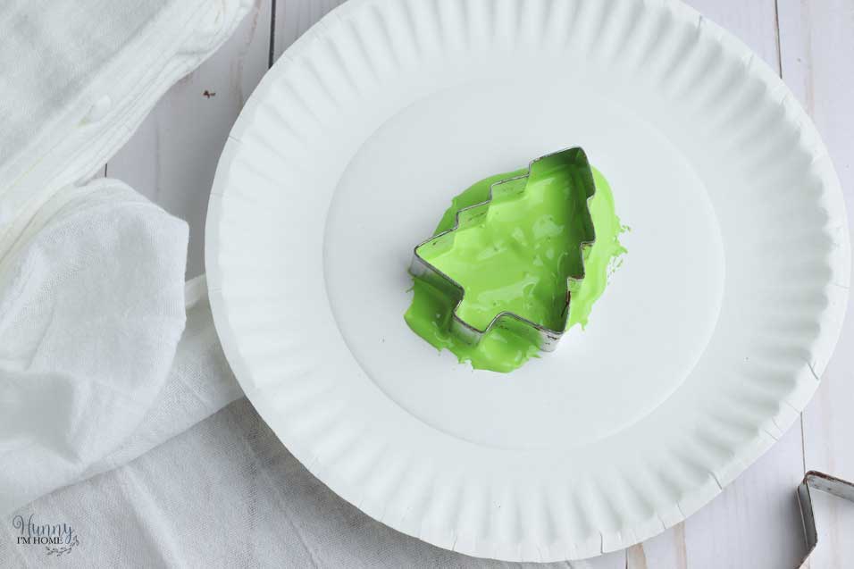 Dip the cookie cutter in the paint