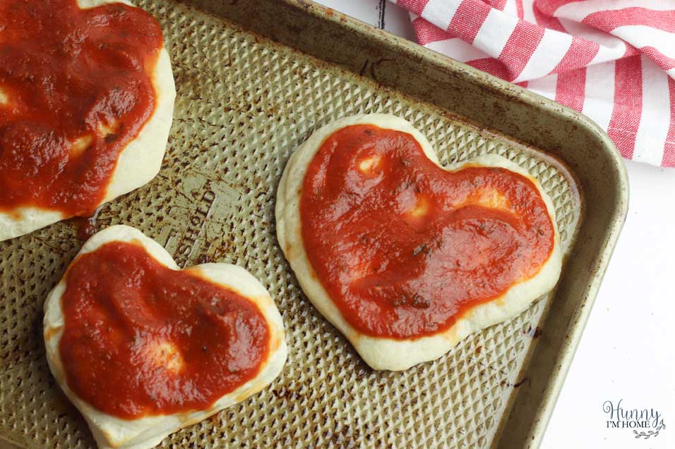 Add the sauce to the heart pizza