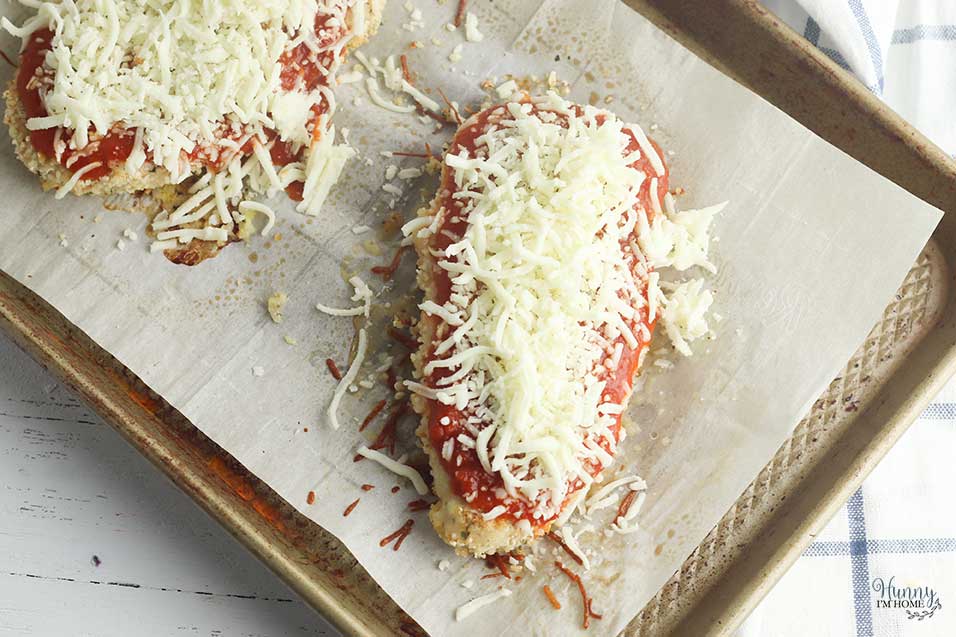 Top chicken parmesan with cheese